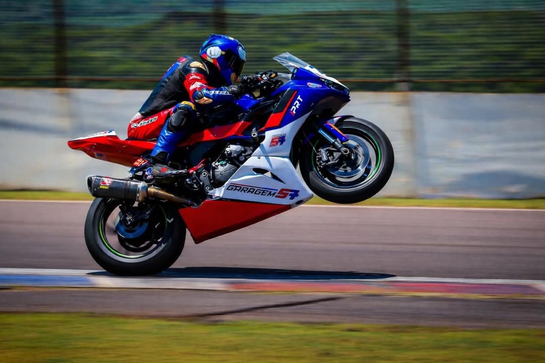 Hilton Loureiro empinando a moto Kawasaki #76 em pista
